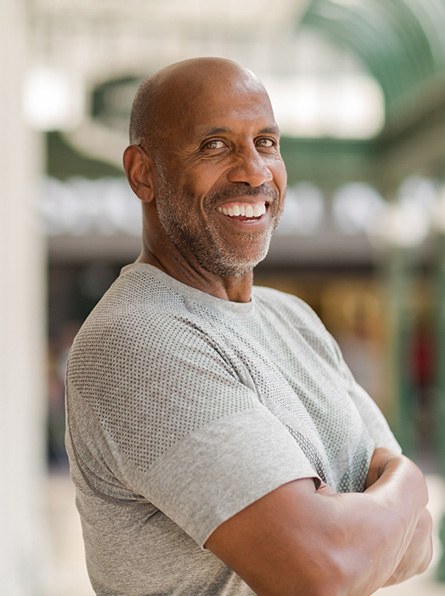 Man in gray shirt smiling outside