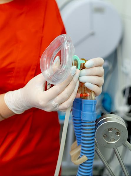 Gloved hands holding mask for nitrous oxide sedation