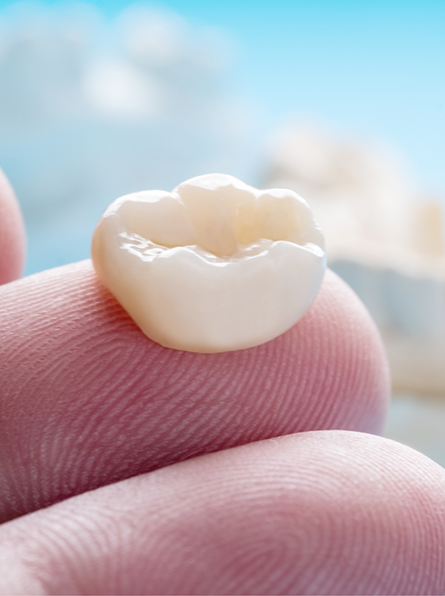 Close up of dental crown on finger