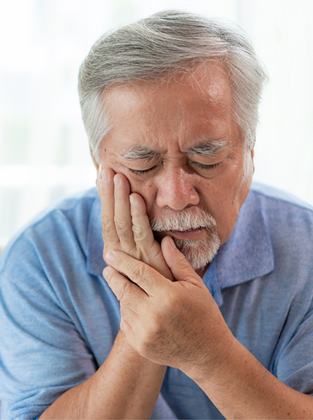 Bearded man with toothache rubbing his jaw
