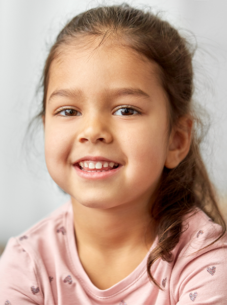 Close up of little girl in pink shirt smiling