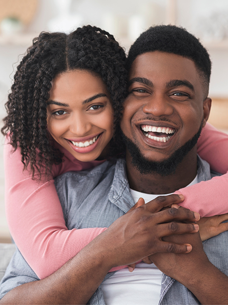 Woman hugging man on couch from behind