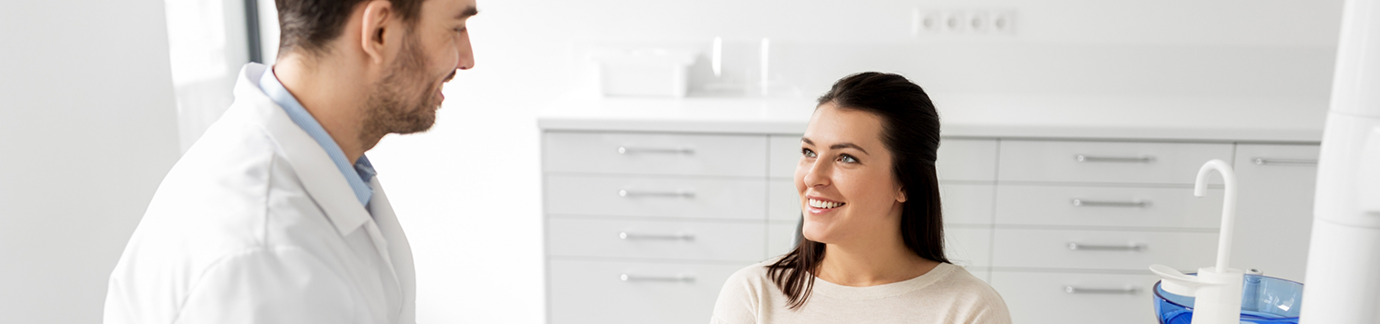 Dentist in Frisco talking to female dental patient